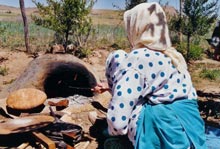 Femme de l\'atlas cuisant son pain dans le four de terre.jpg